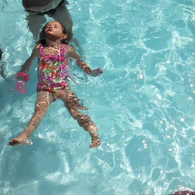 Child learns to back float in swimming