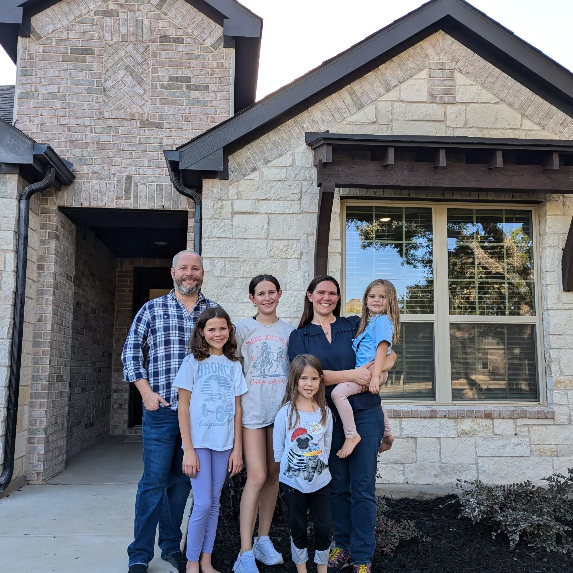 The Hinds family standing in front of their new house the day they bought it.