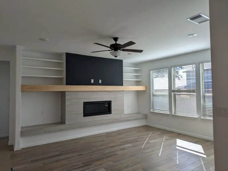 Living room fireplace with a mantle that stretches 16 feet accross with shelves and nooks on every side.