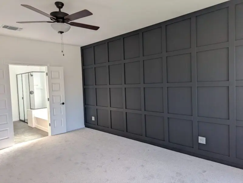 Master bedroom accent wall is black with board and baton trim.