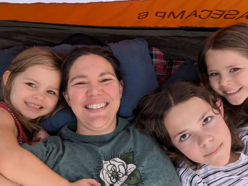 A selfie of Amber, Zara, Addie, and Vivi lying down in a tent.