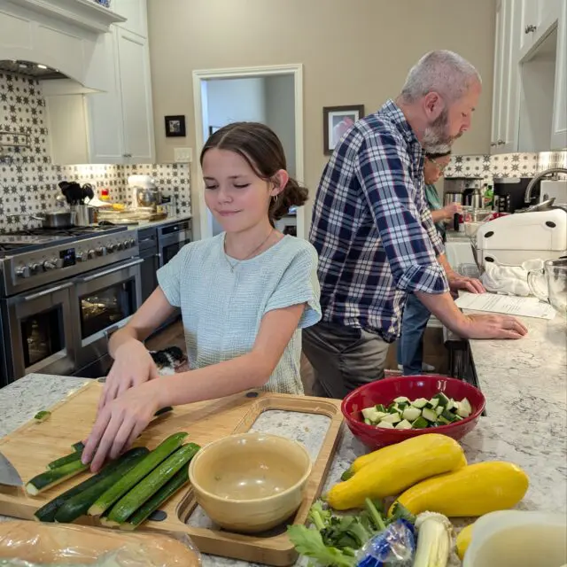 Zara cutting squash> Chris and Amber's mom in the background.