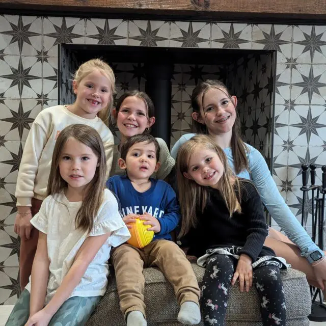 Amber's four daughters pose in front of a fireplace with her niece and nephew.