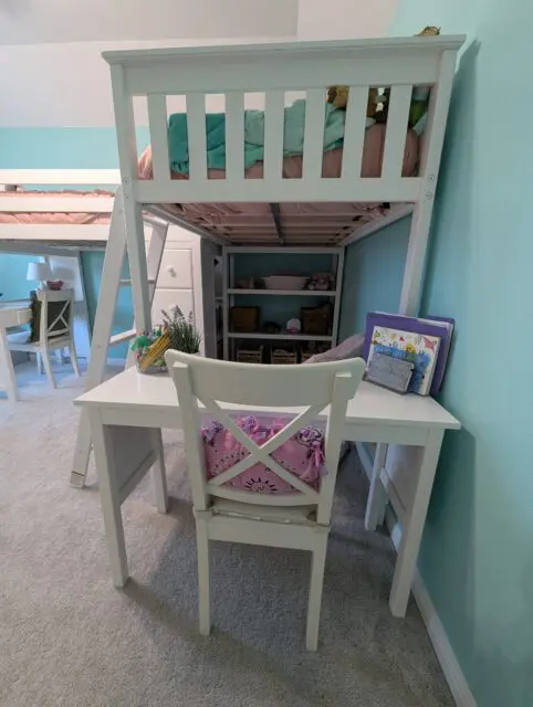 Vivi's new loft bed has a desk off the foot and shelves under the head of the bed.