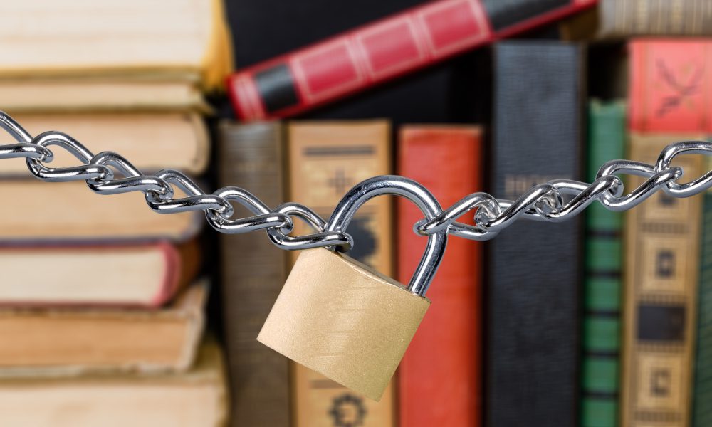 books stacked behind a chain and padlock