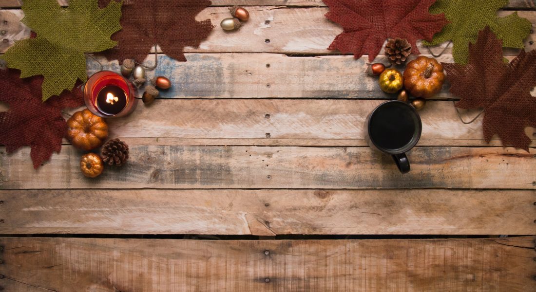 rustic wooden table with pumpkins and leaves