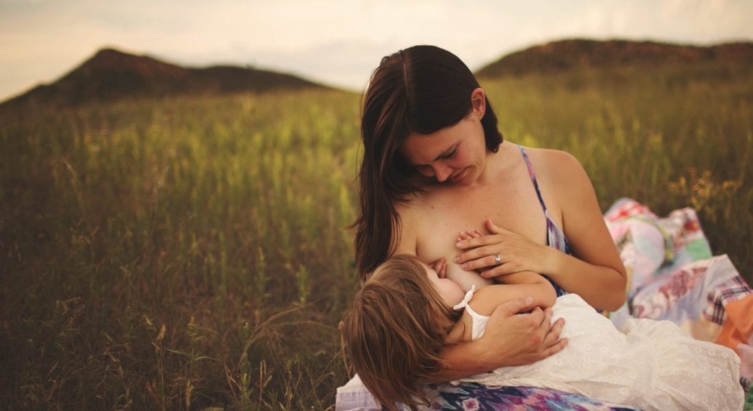 Amber breastfeeding Zara in field