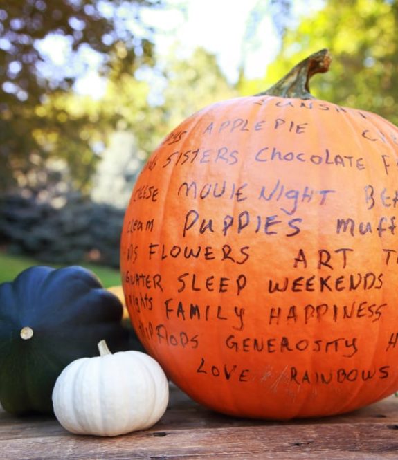 pumpkin with words written all around it of things we're thankful for
