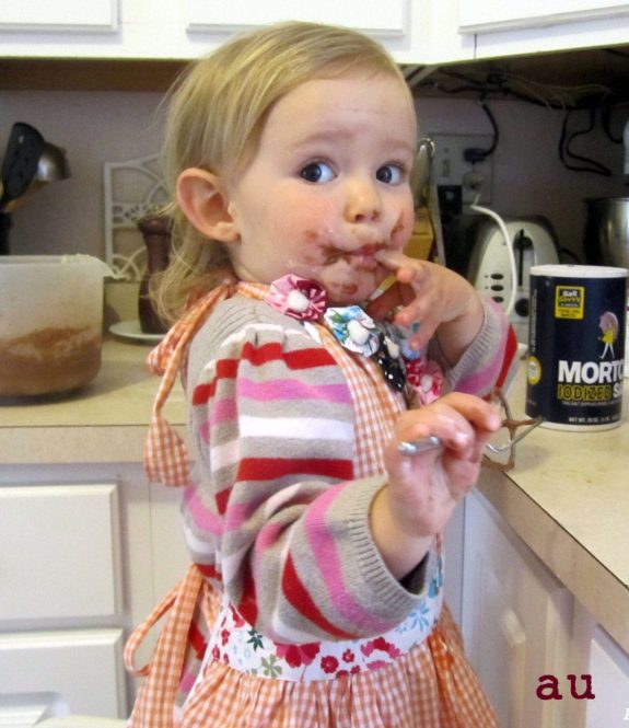 toddler Nora baking with a messy face